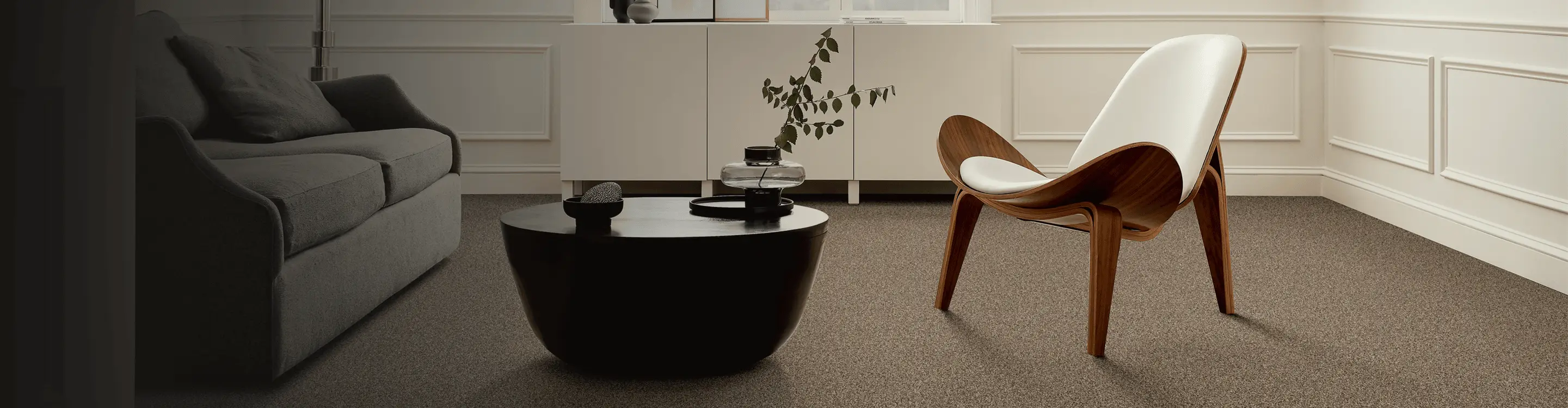Brown carpet in a sitting area with a wooden accent chair